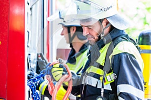 Fire fighter checking the hoses at fire engine