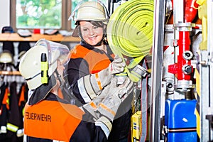 Fire fighters loading hoses into operations vehicle