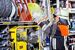 Fire fighters loading hoses into operations vehicle