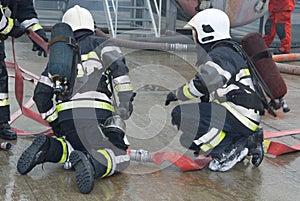 Fire fighters preparing hoses photo