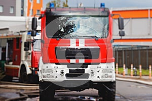 Fire fighting equipment in the city, with red fire engine truck during fire fighting operation in the city streets, vehicle and
