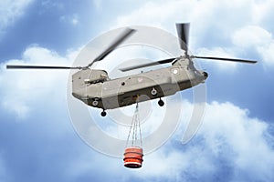 Fire fighting helicopter of the Italian army flying with an empty metal bucket to extinguish a fire