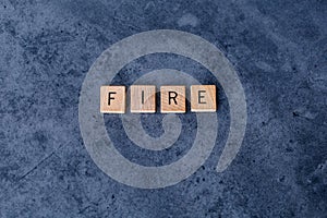 `FIRE` Financial Independence, Retire Early spelled out in wooden letter tiles