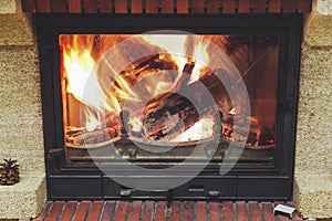 Fire in fireplace. Logs burning in beautiful modern fireplace