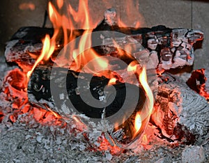 Fire flame, burning wood at the fireplace. Firewood log in the fire chimney, closeup