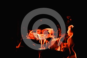 Fire flames on abstract art black background texture. Home Fire burning in brick fireplace. Seasonal and holiday fire A fire burns