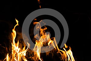 Fire flames on a black background. Abstract fiery texture. Realistic fire flames burn movement frame. Texture for Design. The