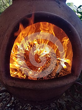 Fire and Flames Inside Clay Chimenea photo