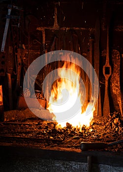 Fire in a foundry with some tools at the background photo