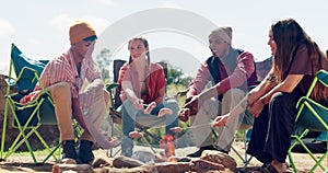 Fire, friends and camping in nature with food, picnic and people together on holiday. Eco travel, group and bonfire on