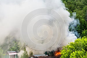 Fire and gray smoke in urban parking area