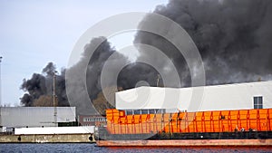 Fire in a harbour, black smoke.