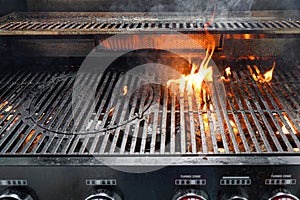 The fire heats up the grate on a gas grill for grilling meat