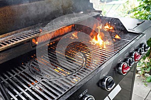 The fire heats up the grate on a gas grill for grilling meat