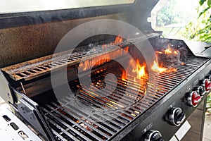 The fire heats up the grate on a gas grill for grilling meat