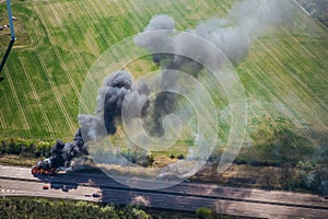 Fire on highway  - strong black smoke rises to the sky, flames are visible - two trucks caught fire on a highway