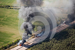 Fire on highway  - strong black smoke rises to the sky, flames are visible - two trucks caught fire on a highway
