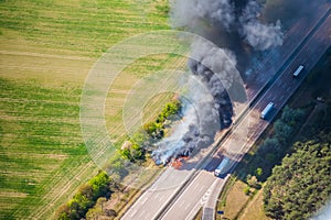 Fire on highway  - strong black smoke rises to the sky, flames are visible - two trucks caught fire on a highway