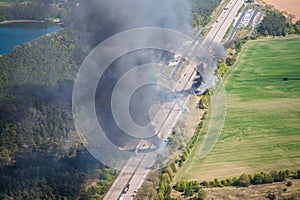 Fire on highway  - strong black smoke rises to the sky, flames are visible - two trucks caught fire on a highway