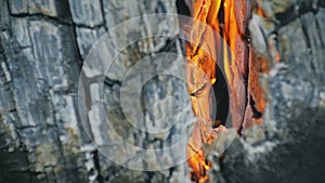 The fire in holes with wood. The bonfire crack chink in Swedish or finnish log candle. Close up.