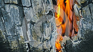 The fire in holes with wood. The bonfire crack chink in Swedish or finnish log candle. Close up.