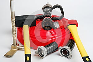 Fire hose, hooligan pinch-bar, yellow sledgehammer, axe from fireman`s toolbox