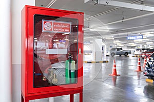 Fire Hose Reel box in the corner of Car Parking., The White Thai Language letter in the middle of the red box means FIRE HOSE REEL