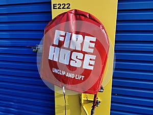 Fire hose reel mounted on yellow wall