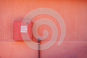 Fire hose reel on the terracotta exterior wall of the house