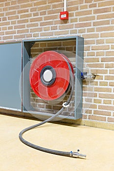 Fire hose on reel at wall