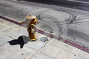 Fire Hydrant to extinguish a fire on the sidewalk near the roadway paved road.