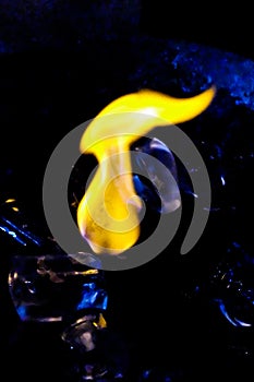 Fire and ice Burning ice cube on a shiny surface blue tone