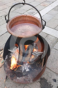 fire lit to boil water inside the large copper cauldron during h