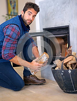 Fire, log and portrait of man at fireplace for heat, warmth and light in winter in home. Season, burning and person with