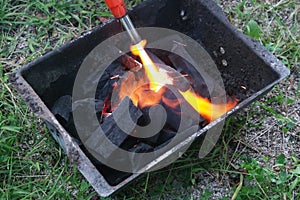 Fire on logs in fire pot with embers and burning coal and blazing flames