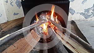 Fire on logs in fire pot with embers and burning coal and blazing flames