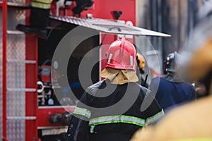 Fire men in protective uniform during fire fighting operation in the city streets, firefighters brigade with the fire