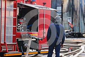 Fire men in protective uniform during fire fighting operation in the city streets, firefighters brigade with the fire