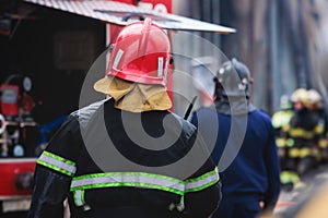 Fire mens in protective uniform during fire fighting operation in the city streets, firefighters brigade with the fire