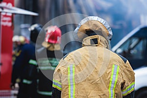 Fire mens in protective uniform during fire fighting operation in the city streets, firefighters brigade with the fire