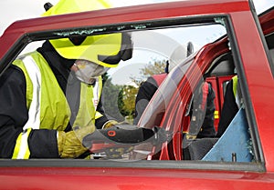 Fire officer cutting away a car roof at car smash