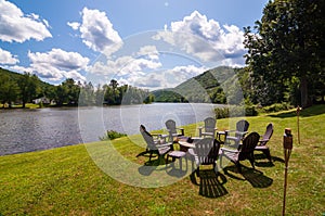 A fire pit surrounded by adirondack chairs next to the Allegheny river in Warren county, Pennsylvania, USA