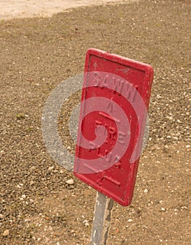 Fire plug sign with gravel and dirt background