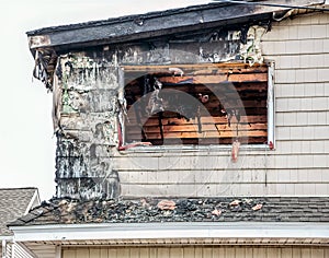 A fire ravaged shell of a residential building showing exterior and interior damage.