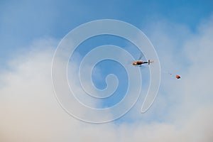 Fire rescue helicopter in the sky, with water bucket