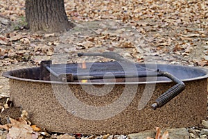 Fire ring with smoke and flames, autumn leaves in background