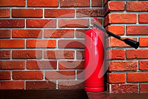 Fire safety background with fire extinguisher on the red bricks wall