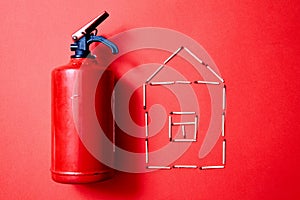 Fire safety, or security and protection concept. Fire extinguisher and the figure of the house of matches