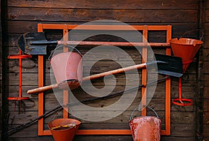 Fire shield with equipment on a wooden wall. Fire safety of rustic house