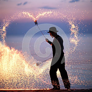 Fire show on the beach at sunset